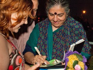 Vandana Shiva signiert von einem Fan einen Flyer. 