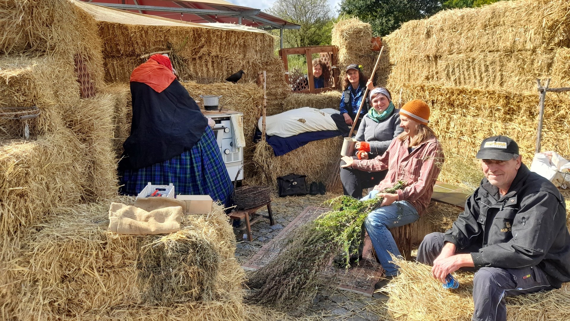 Das Kräutergarten-Team beim Erntemarkt, umgeben von Heuballen.