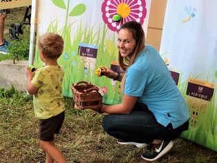 Eine Outdoor-Veranstaltung mit Kindern und Erwachsenen in einer fröhlichen Atmosphäre.
