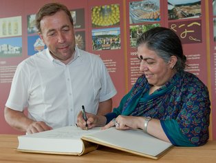 Vandana Shiva verewigt sich hier in ein großes Buch von ALB-GOLD.