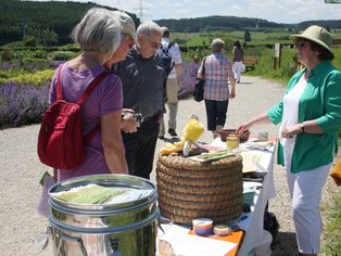 Eine Gruppe ältere Menschen, die vor einem Informationsstand stehen und sich beraten lassen.