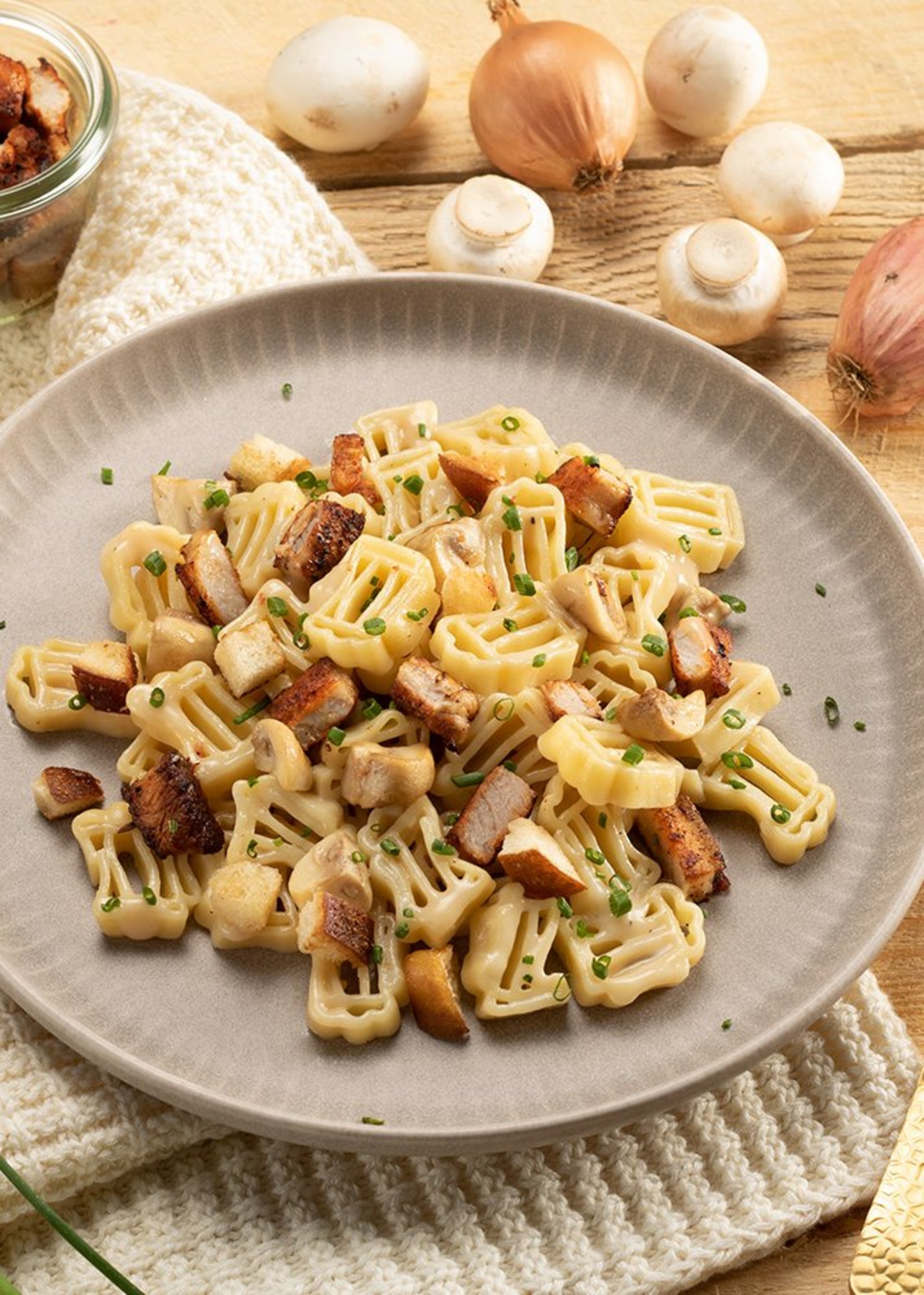 Leckere Bierkrug-Pasta mit saftigen Pilzen und herzhaftem Speck, ansprechend angerichtet für ein genussvolles Essen.