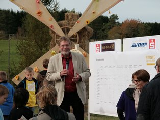 Ein Redner spricht bei einer Festveranstaltung vor einer Gruppe von Menschen.