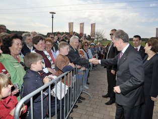 Horst Köhler steht vor einer großen Menschenmasse und begrüßt Leute mit einem Handschlag.