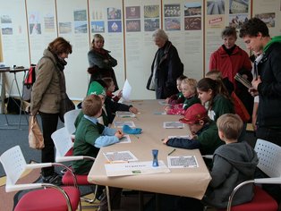Gemeinschaftsveranstaltung mit Kindern und Erwachsenen in einem Raum.