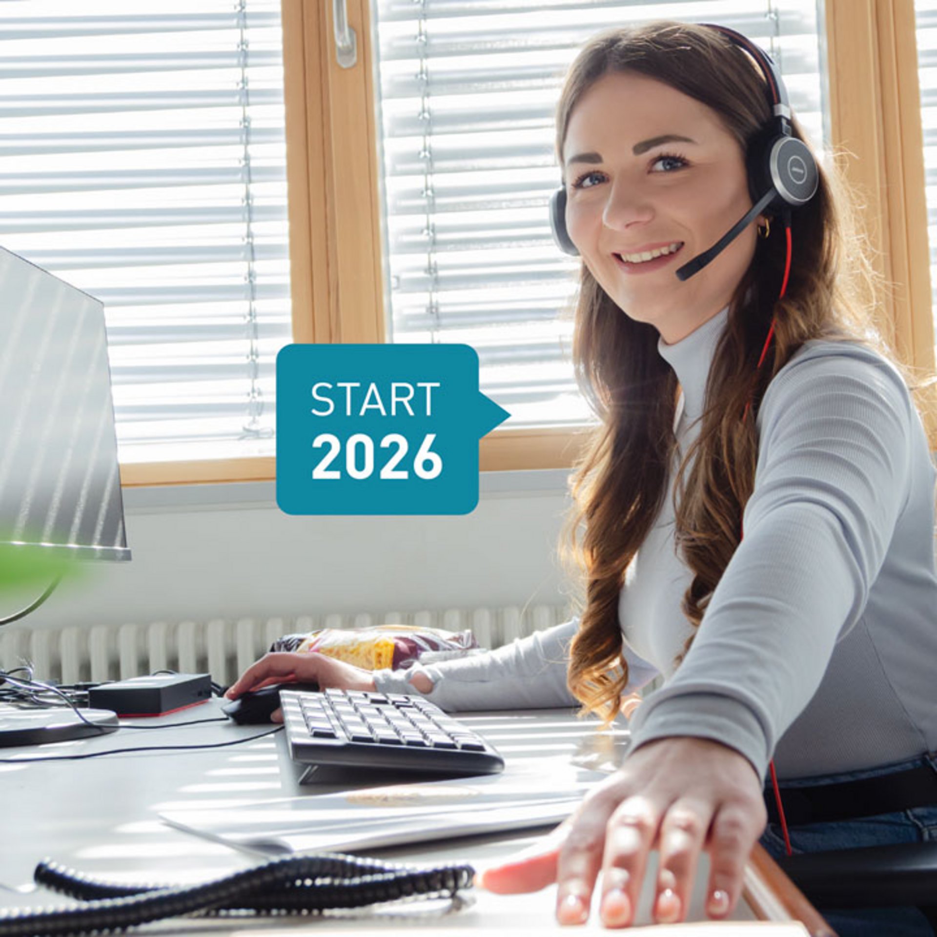 Eine freundliche Kundenservice Mitarbeiterin, die am Schreibtisch arbeitet und ein Headset trägt. Eine freundliche Kundenservice Mitarbeiterin, die am Schreibtisch arbeitet und ein Headset trägt.