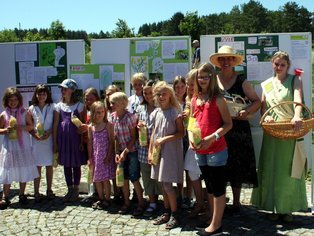 Kindergruppe posiert fröhlich beim Fest mit Getränken.