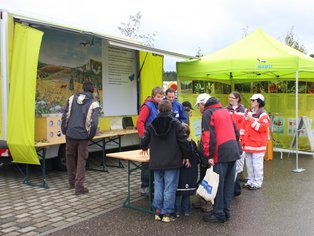 Teilnehmer, die sich um einen Informationsstand versammeln