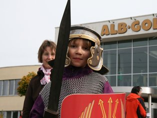 Ein Kind in römischer Rüstung mit Schild und Schwert.