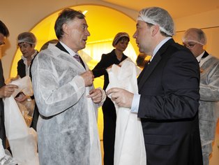 Mehrere Menschen stehen beisammen und ziehen sich die Schutzkleidung für die Produktion an.