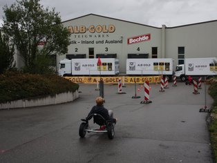 Kind fährt mit einem Kart auf der Rennstrecke vor dem Restaurant.