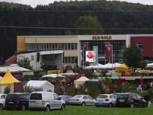 ALB-GOLD Gebäude und parkende Autos im Vordergrund.