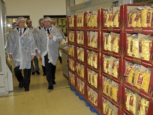 Menschen bei einer Produktionsführung, die sich fertig gepackte Displays anschauen.